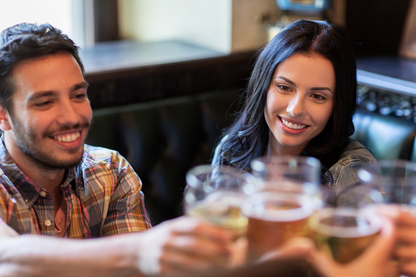 happy friends drinking beer at bar or pub - Foto, Bild