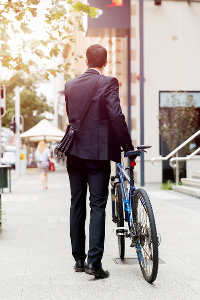 Young businessmen with a bike - Foto, Imagen