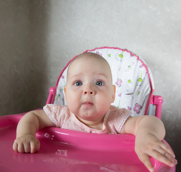 Retrato de um bebê sentado em uma cadeira alta
 - Foto, Imagem