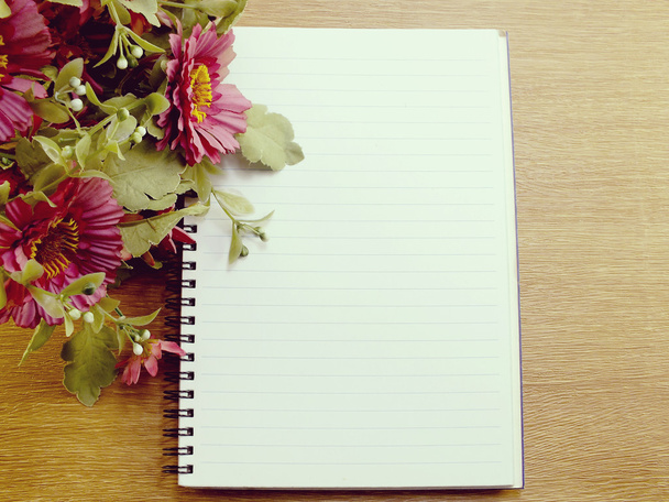 blank notebook with flower on wooden table - Φωτογραφία, εικόνα