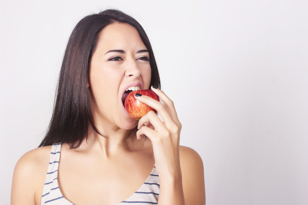 Young caucasian woman eating an apple - Fotó, kép