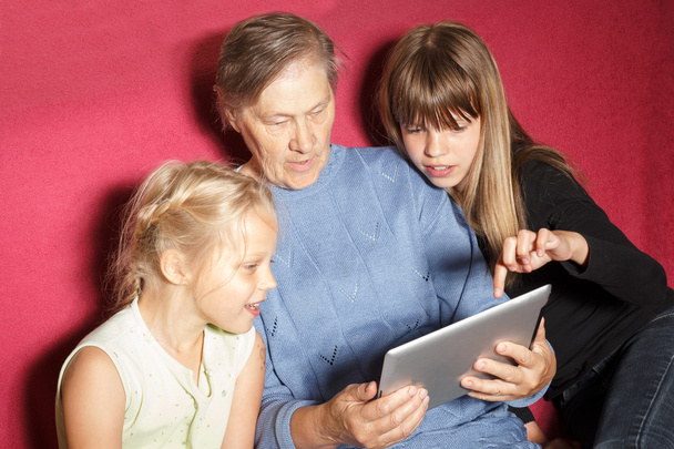 Dos niñas y abuela usando tableta digital
 - Foto, imagen