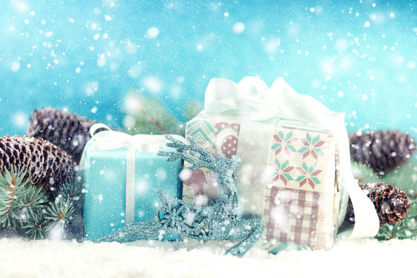 Christmas wenskaart met geschenkdozen en takken in de sneeuw - Foto, afbeelding
