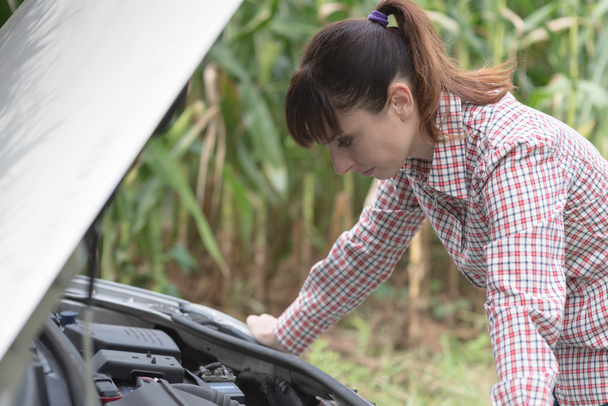 Woman trying to repair her broken car - Photo, Image