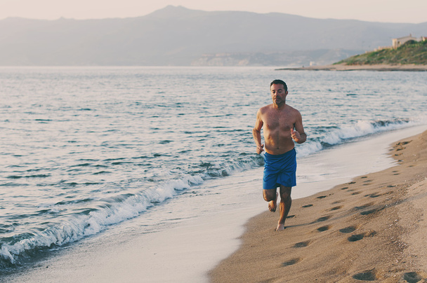Mies juoksee rannalla - Valokuva, kuva