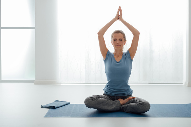 Junge Frau praktiziert Yoga - Foto, Bild