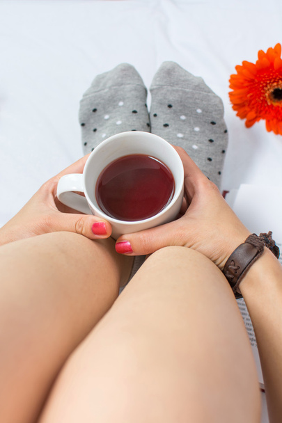 ベッドでお茶のカップを保持している女性 - 写真・画像