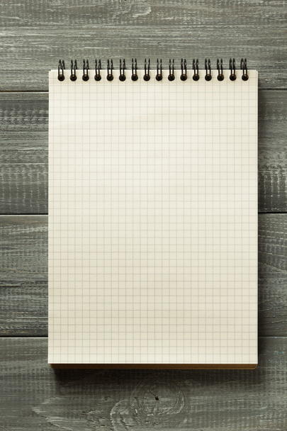 checked notebook on wooden table - Photo, image