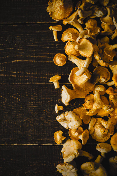 Chanterelles at the right of the wooden table vertical - Foto, afbeelding