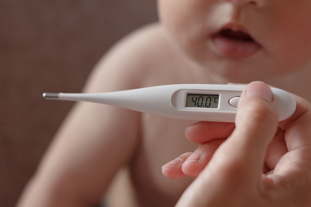 Madre mide la temperatura de un niño
 - Foto, Imagen