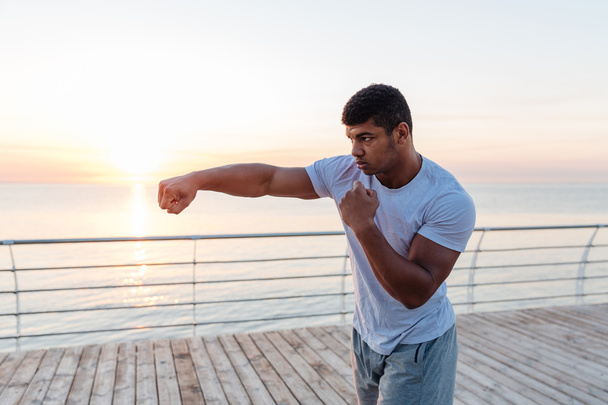 Handsome african man athlete boxing outdoors on sunrise - 写真・画像