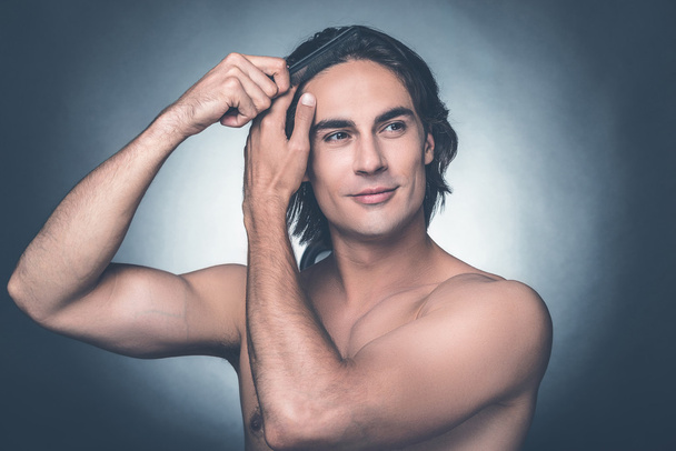 man combing his hair with hairbrush  - Photo, Image