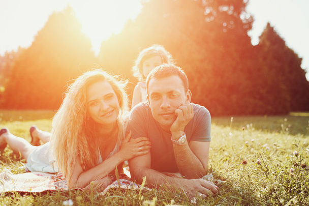 Feliz familia joven pasar tiempo juntos fuera en la naturaleza verde. - Foto, Imagen