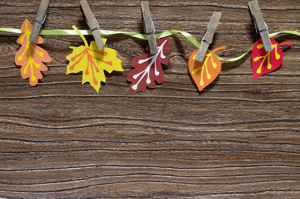 Autumn background with colored paper sheet on a wooden board. A  - Photo, Image