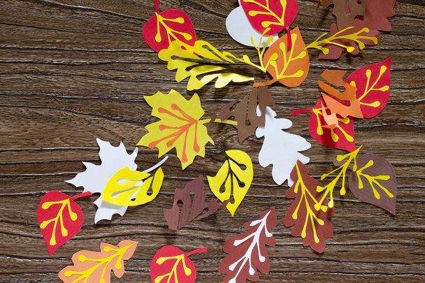 Fond d'automne avec feuille de papier coloré sur une planche en bois. A
  - Photo, image