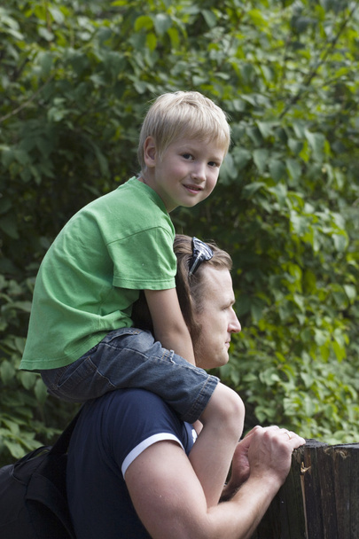 niño se sienta en el padre sobre los hombros
 - Foto, imagen