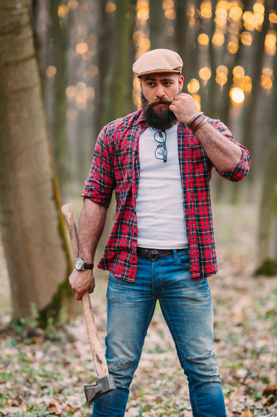 Bearded lumberjack in the woods - Fotoğraf, Görsel
