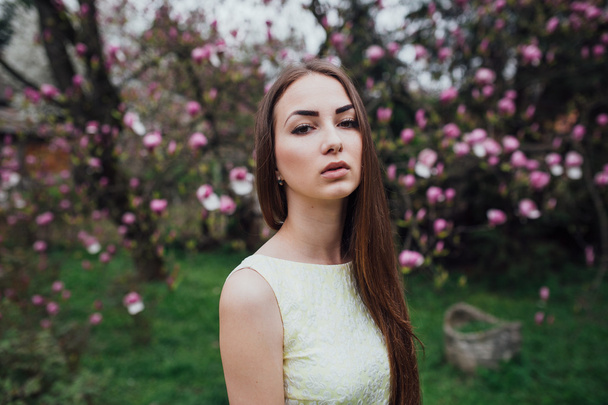Piękna dziewczyna w pobliżu magnolia - Zdjęcie, obraz