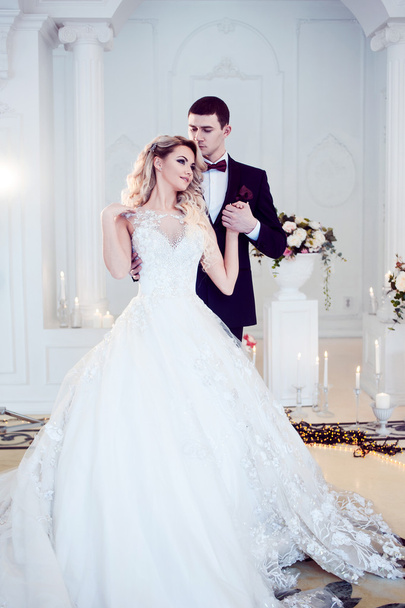 Beautiful young couple, the bride and groom. Luxurious light interior - Φωτογραφία, εικόνα