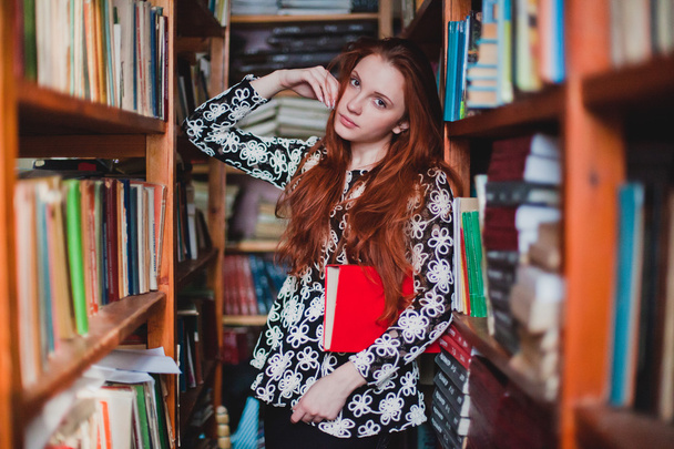 young redhead girl in library - Foto, Imagen