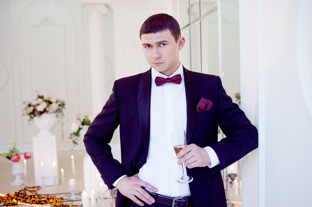 Young man at the wedding, the groom with a glass of champagne - Fotoğraf, Görsel