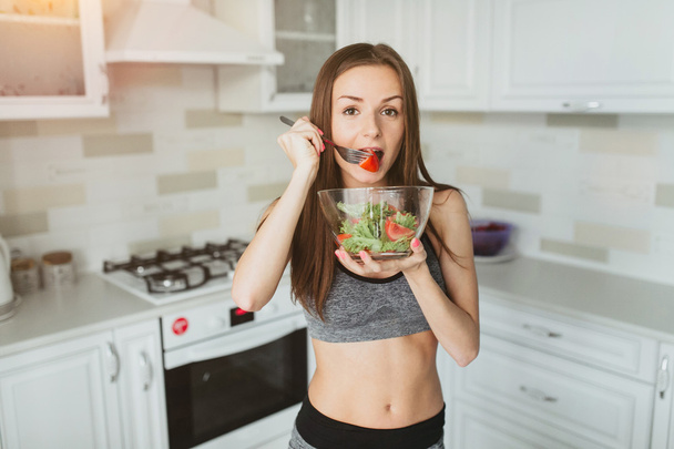 young girl with salad after workout - Foto, imagen