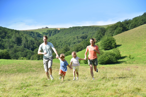 Familie rennt den Berg hinunter - Foto, Bild
