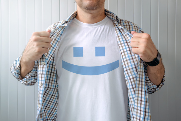 Man stretching shirt to reveal smiley emoticon - Zdjęcie, obraz