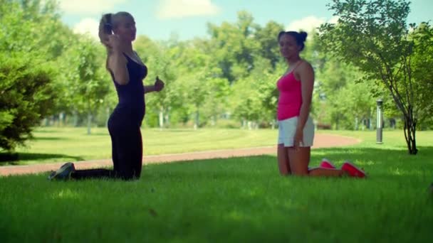 Молодая женщина разговаривает на коленях на зеленой траве в парке
 - Кадры, видео