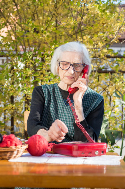 Femme âgée utilisant le téléphone dans la cour arrière
 - Photo, image