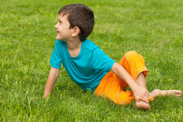 Маленький мальчик на траве смотрит в сторону
 - Фото, изображение