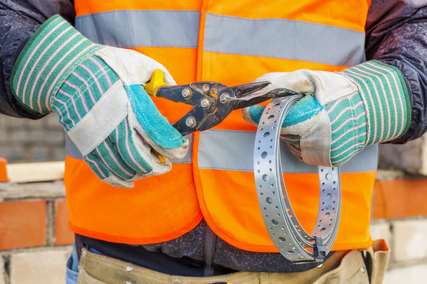 Construction worker with metal Cutting shears and mounting tape - Foto, imagen
