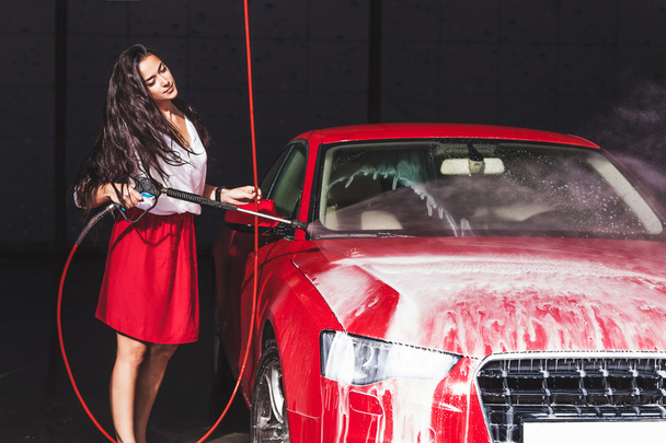 Woman washing a red sports car - Photo, Image
