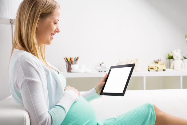 Pregnant woman using tablet - Foto, afbeelding