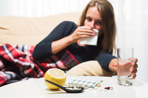 毛布のくしゃみと鼻拭きの下でソファに横たわっている病気の女性。風邪をひいた - 写真・画像