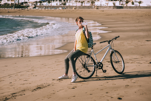 Sports girl cyclist on the beach - Photo, Image