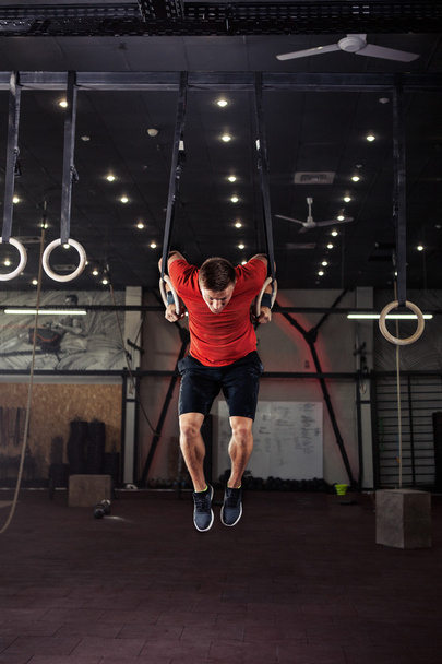Athlet trainiert seine Muskeln an Ringen - Foto, Bild