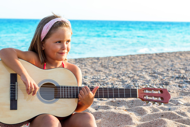 девушка с повязкой на голове играет на гитаре
 - Фото, изображение