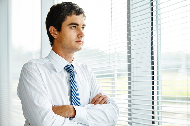 Pensive бізнесмен дивиться крізь вікно
 - Фото, зображення