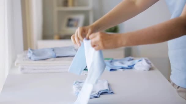 pregnant woman folding baby boys clothes at home 26 - Video, Çekim