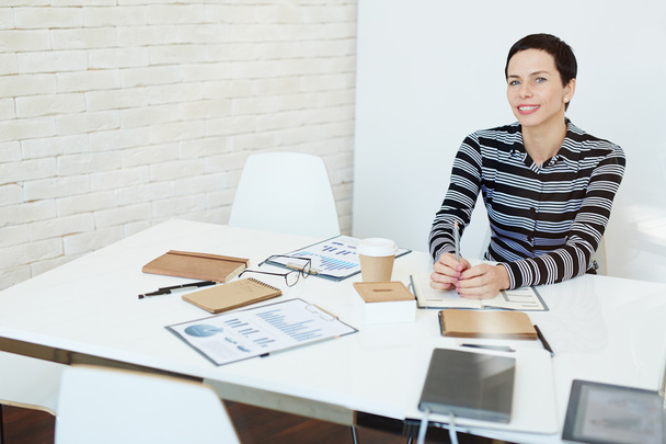Podnikatelka, sedí na jejím pracovišti a usmívá se  - Fotografie, Obrázek