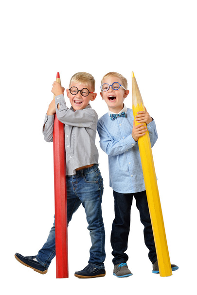 Full length portrait happy young boys in glasses and bowtie posing near huge colorful pencils. Educational concept. Isolated over white. - Fotografie, Obrázek