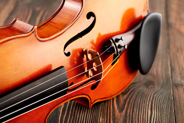 Κοντινό πλάνο του μια λεπτομέρεια βιολί στο ξύλινο τραπέζι - Φωτογραφία, εικόνα