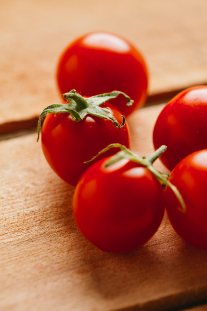 Fresh cherry tomatoes on a wooden background - Fotó, kép