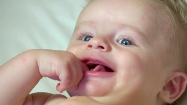 Retrato de bebé recién nacido sonriendo en cuna
 - Imágenes, Vídeo