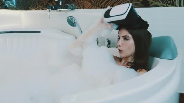 Chica tomar baño lleno de espuma en el baño de posponer gafas de realidad virtual. Dispositivo
 - Imágenes, Vídeo