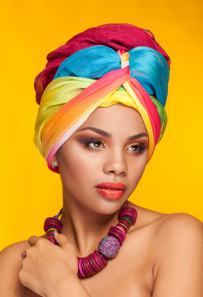 Afro american girl wearing an ethnic turban on yellow background - Foto, Bild