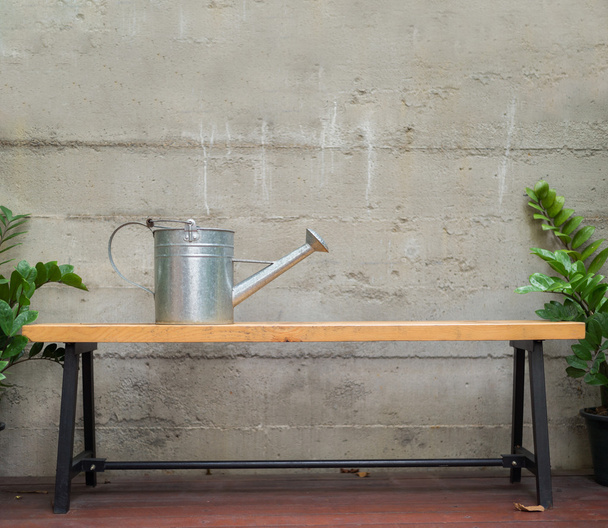 tin watering can on wooden bench - Photo, Image