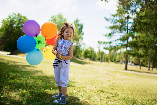 Little Girl Holding Balloons in park - Foto, Imagem