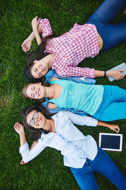 happy students lying on green grass - Photo, Image